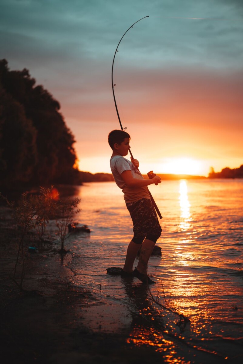 boy fishing at sunset