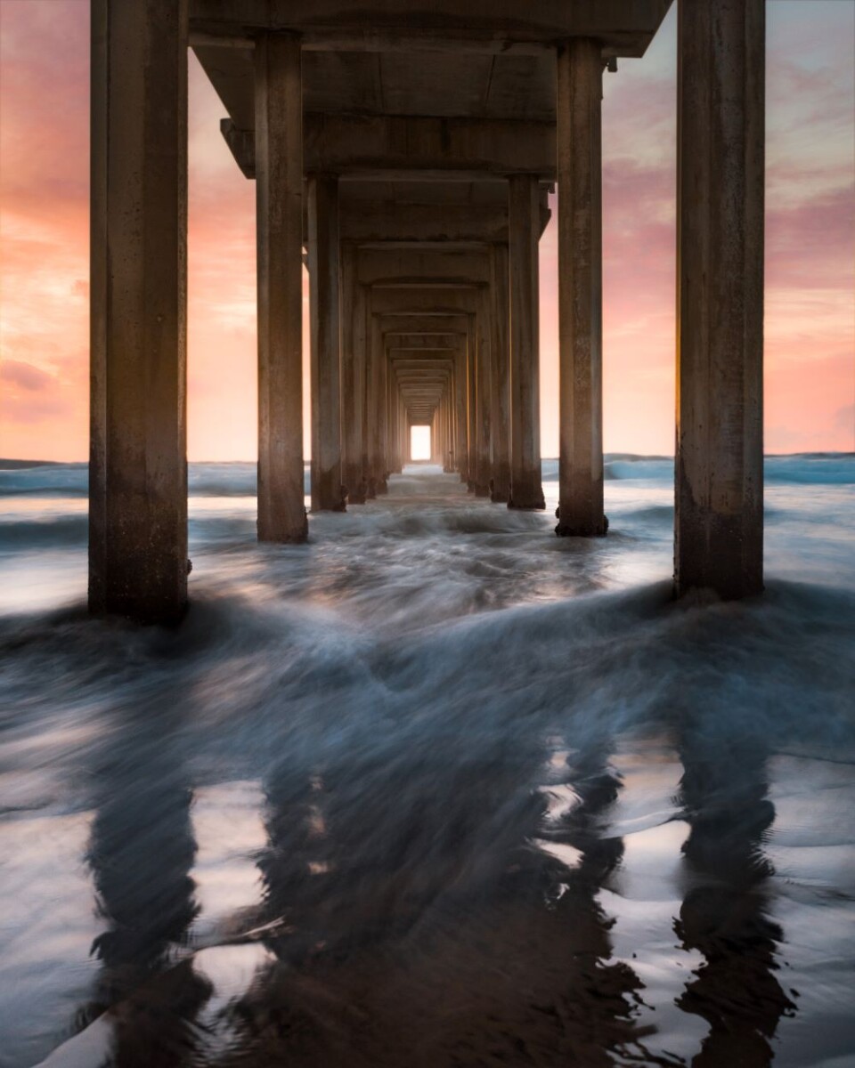 looking at the ocean from underneath a pier