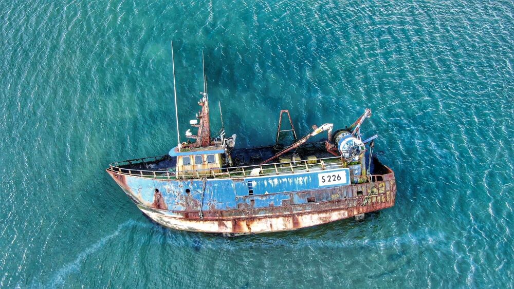 shipwrecked boat in blue water
