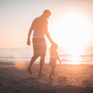 man walking on the beach with child