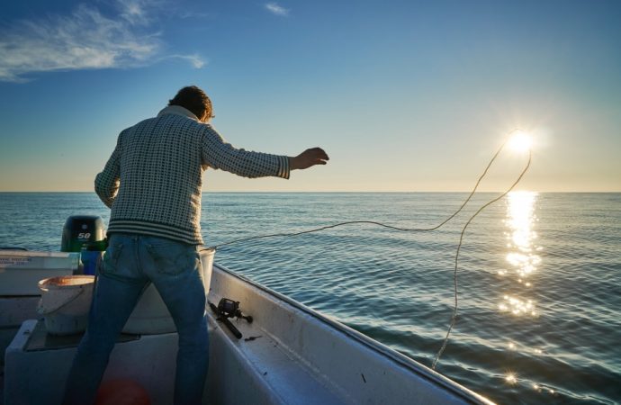 man fishing off a boat