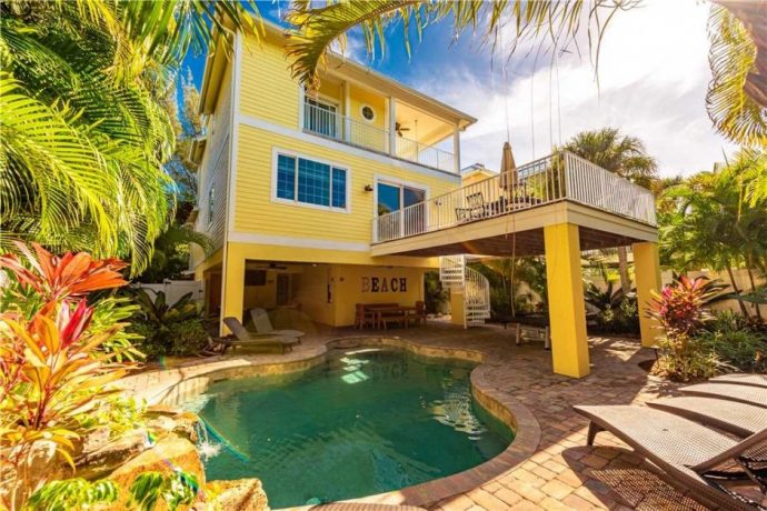 Exterior of multilevel yellow house with pool in Anna Maria Island